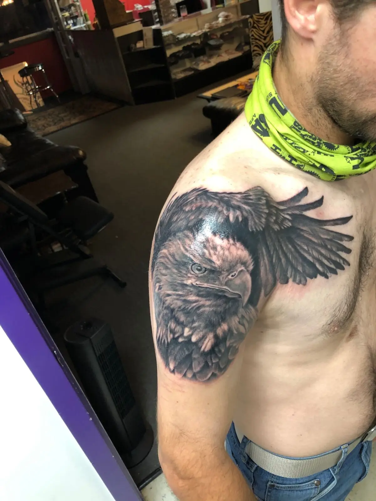 Black and grey eagle shoulder tattoo with spread wing and detailed feather work