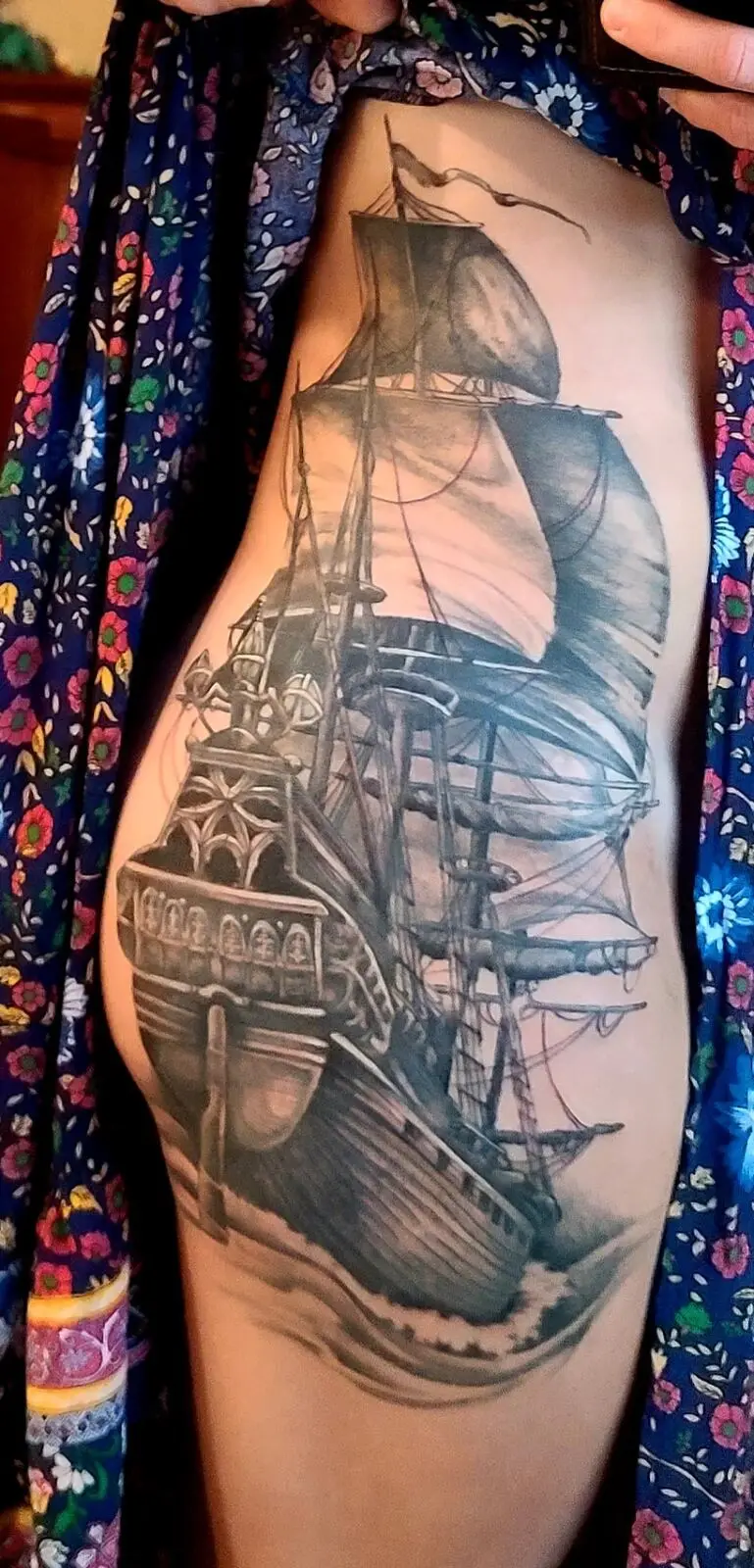 Black and grey pirate ship rib tattoo with sweeping sails and detailed rigging