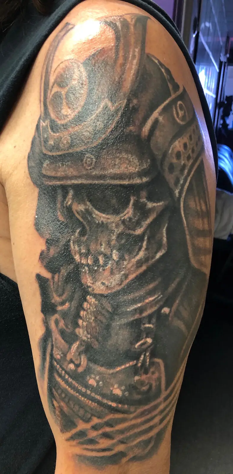 Black and grey samurai skull with kabuto helmet half sleeve tattoo on upper arm