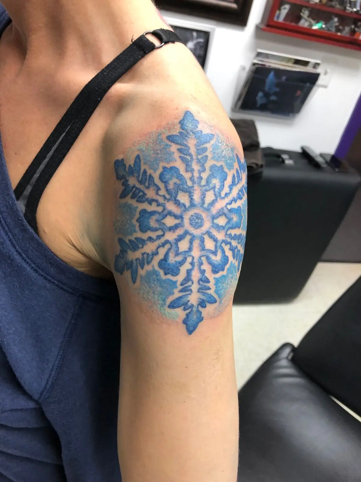 Large blue snowflake shoulder tattoo with negative space detail